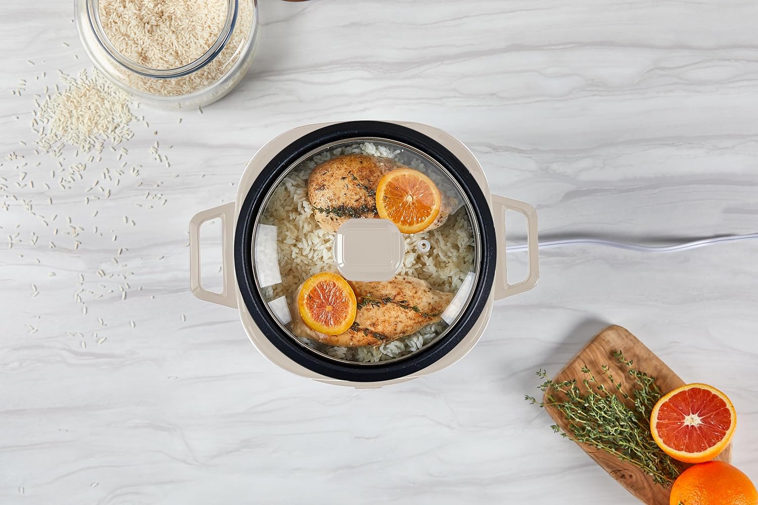 Cooking pot with food on a light gray surface, surrounded by oranges and oats.