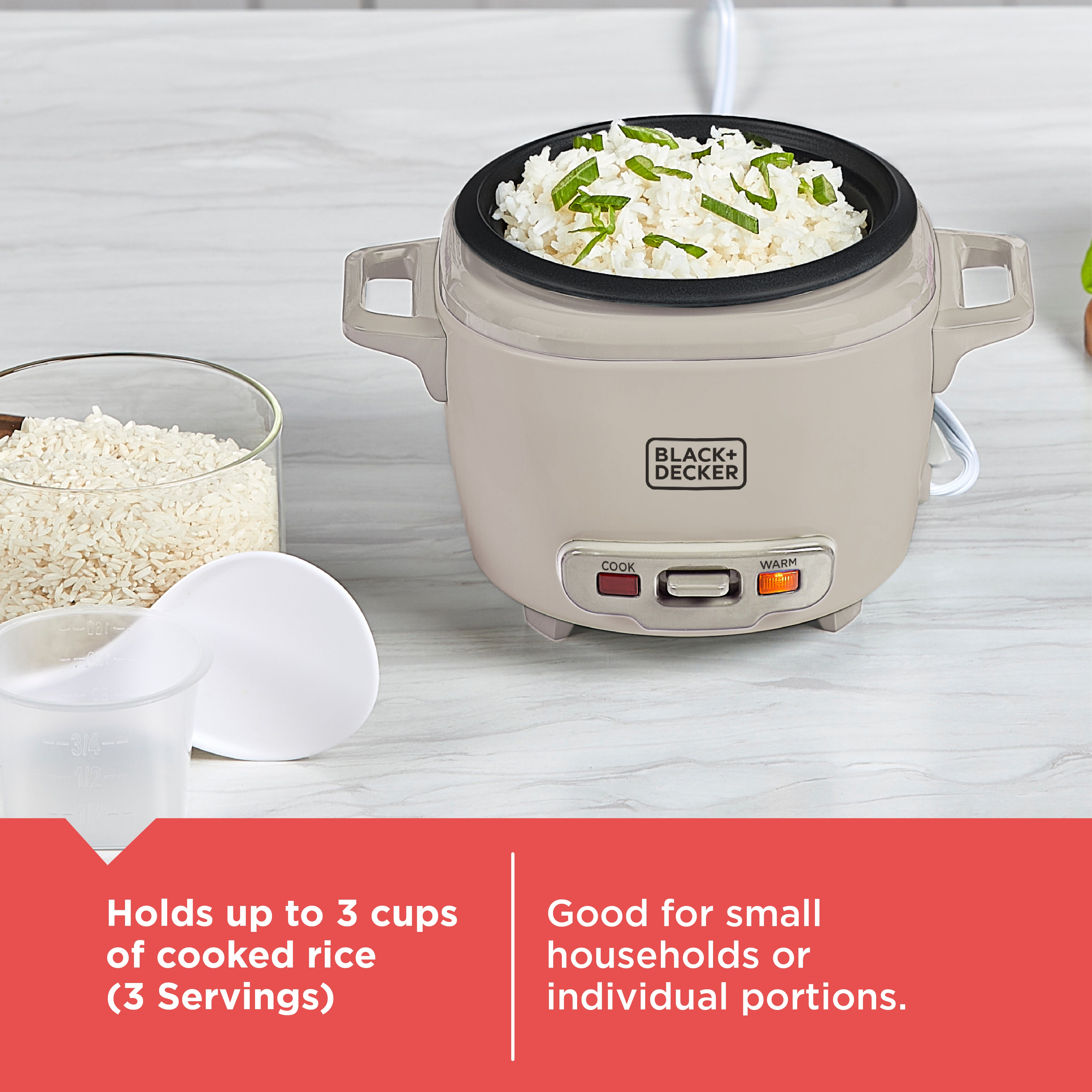 Black+Decker rice cooker with cooked rice and green vegetables on a white surface