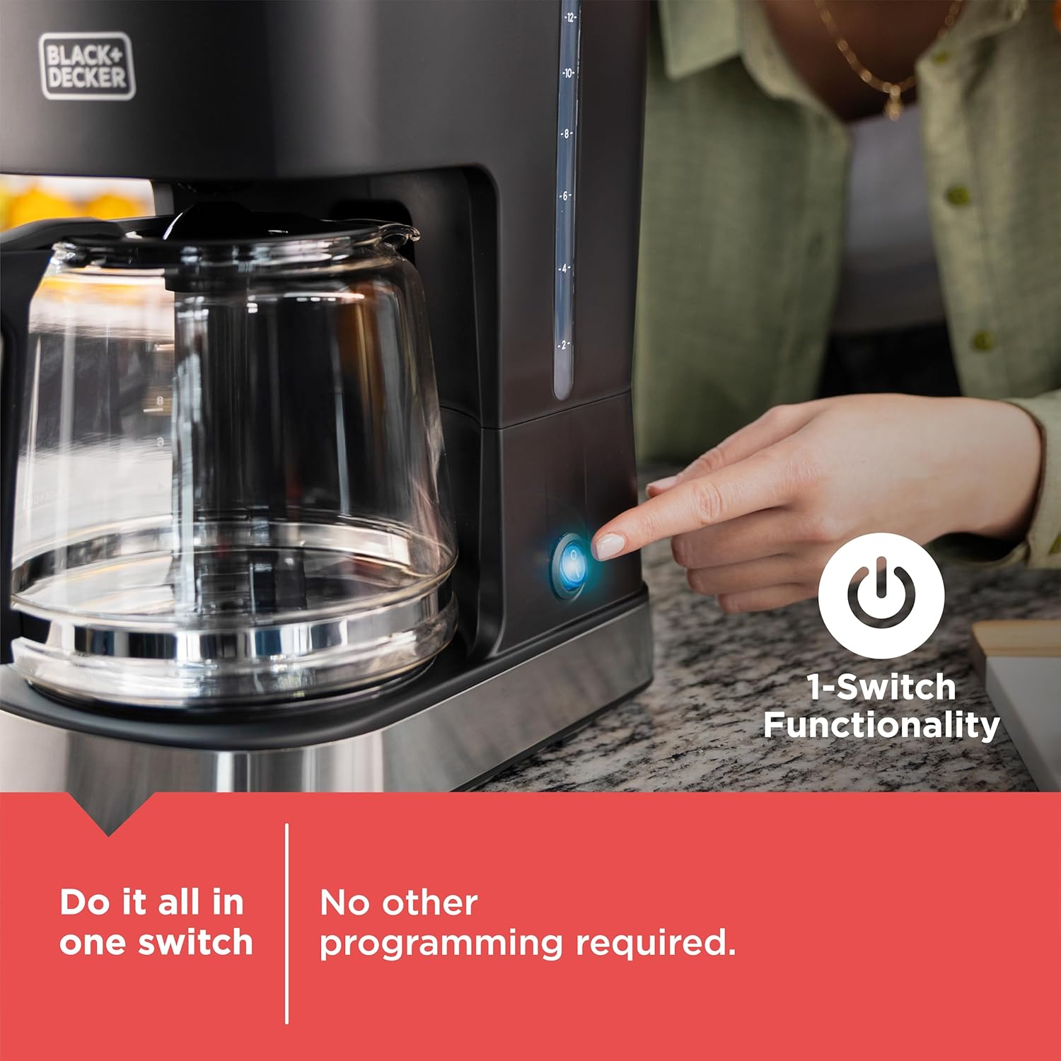 Coffee maker with a hand pressing a button, featuring Black+Decker branding.