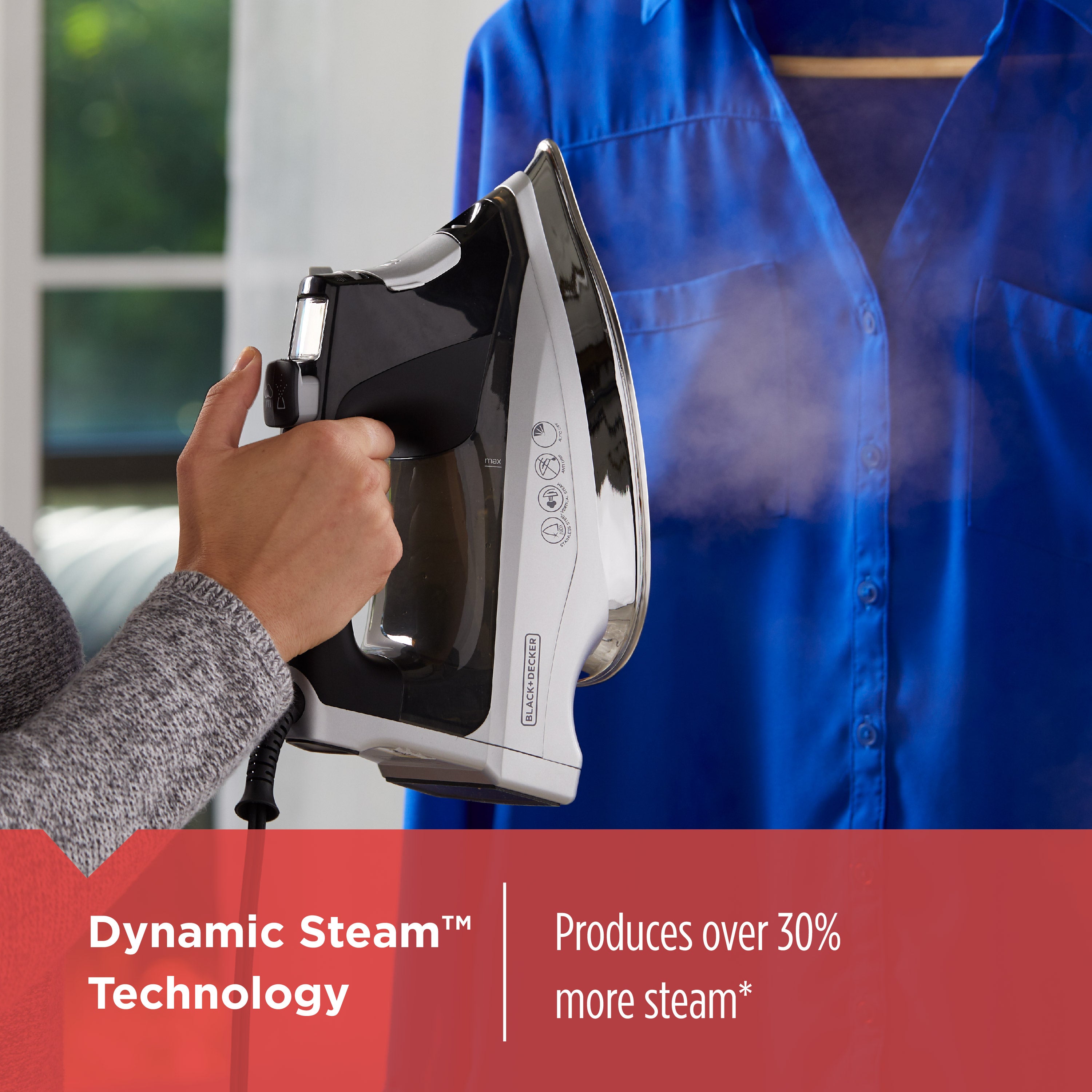 Person ironing a blue shirt with dynamic steam technology text overlay