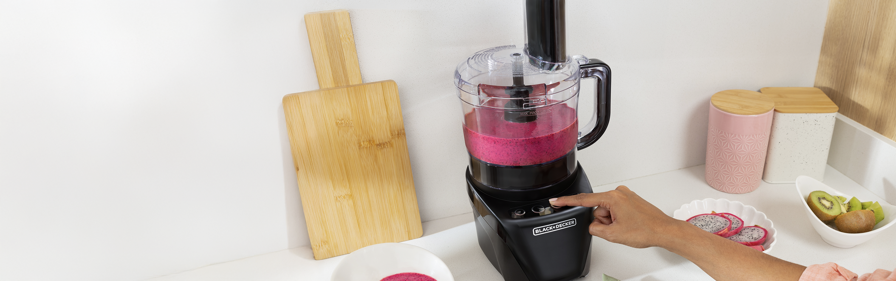 Black food processor with pink liquid on a kitchen counter