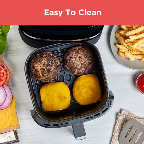 Air fryer with cooked food items on a table with text 'Easy To Clean'.
