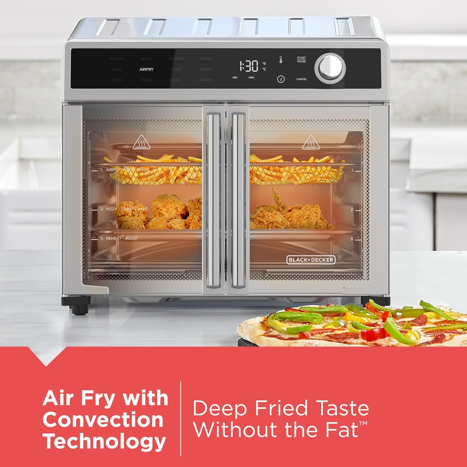 Black+Decker air fryer with food items inside, displayed on a white surface.
