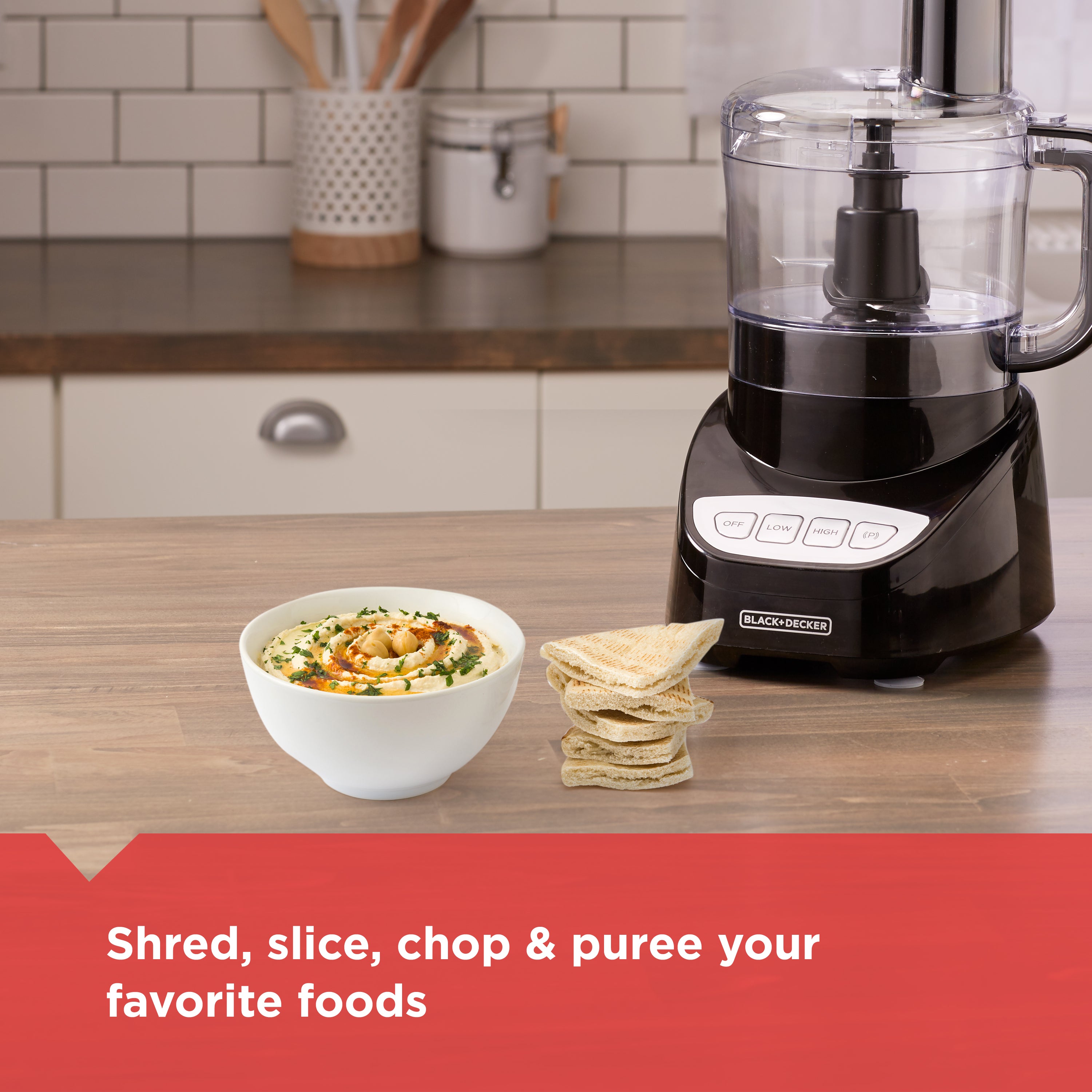 Black food processor on a kitchen counter with a bowl of food and tortilla chips, featuring the brand 'Black+Decker'.