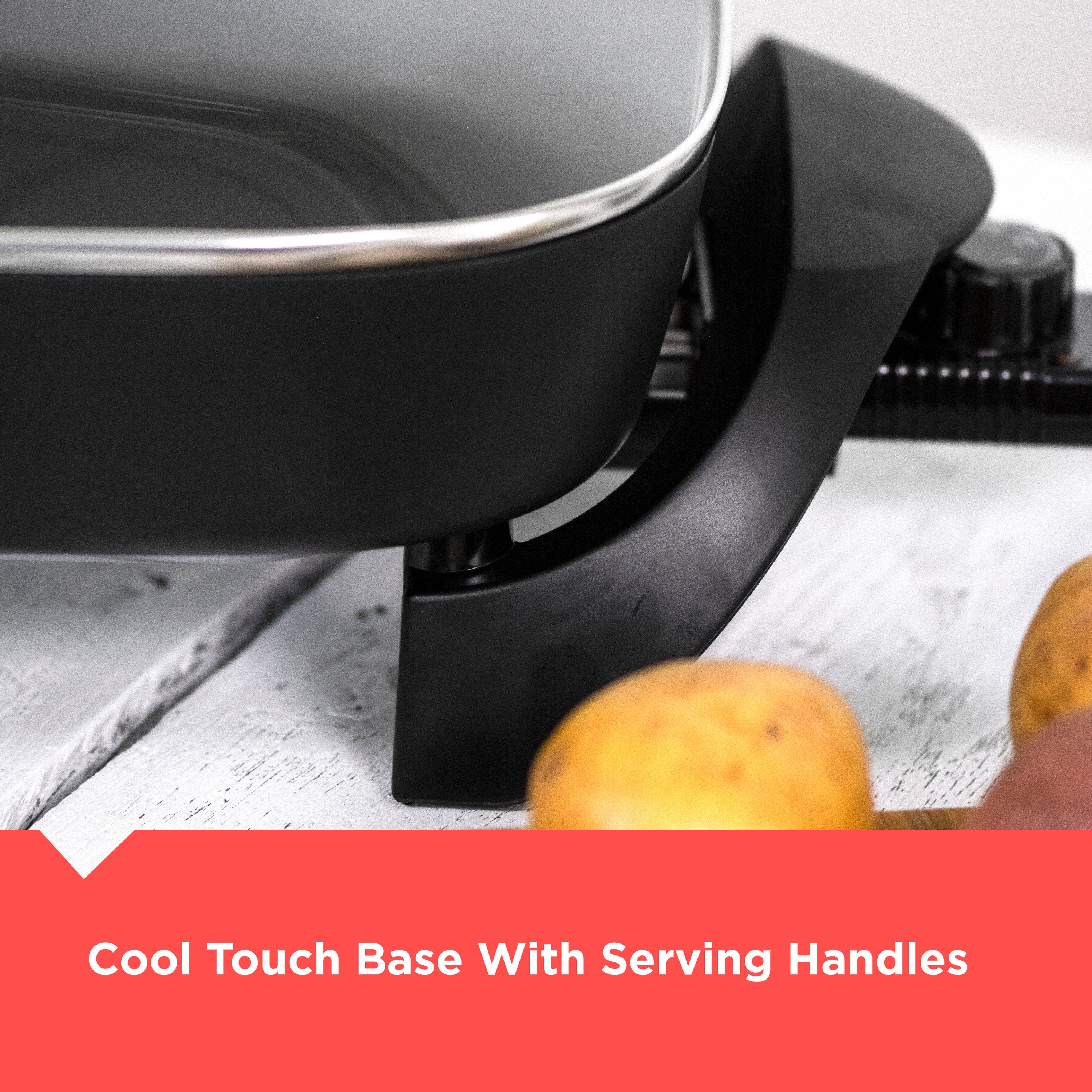 Black electric frying pan with cool touch base and serving handles on a white surface.