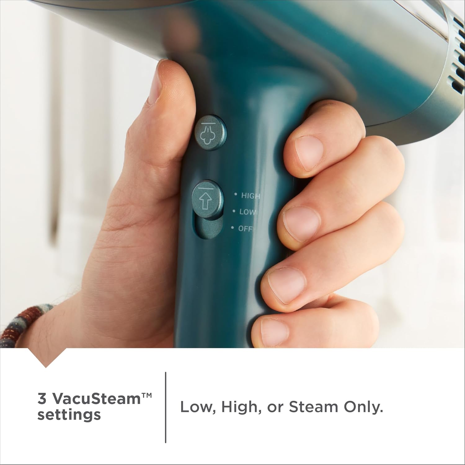 Hand holding a teal handheld device with control buttons on a white background
