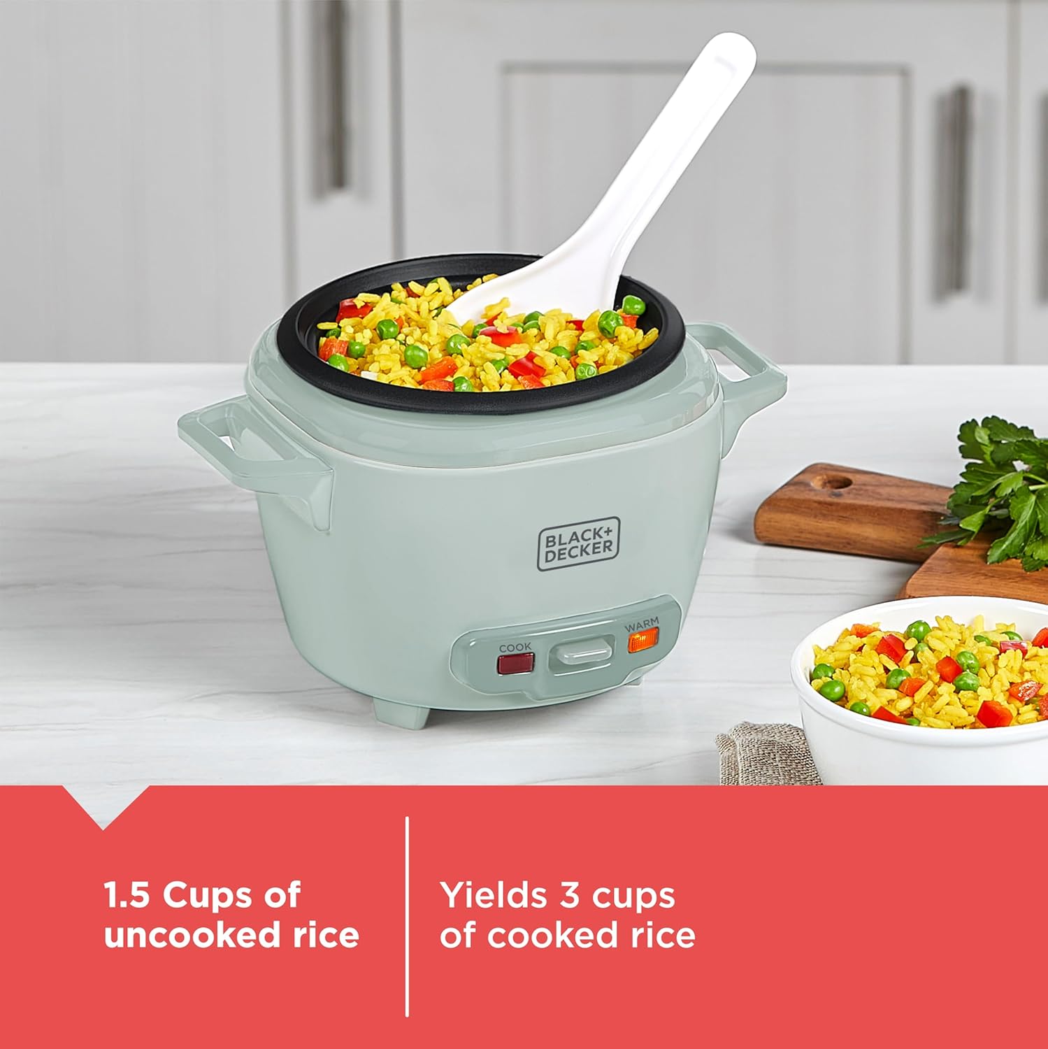 Green rice cooker with cooked rice and vegetables on a kitchen counter, featuring Black+Decker branding.