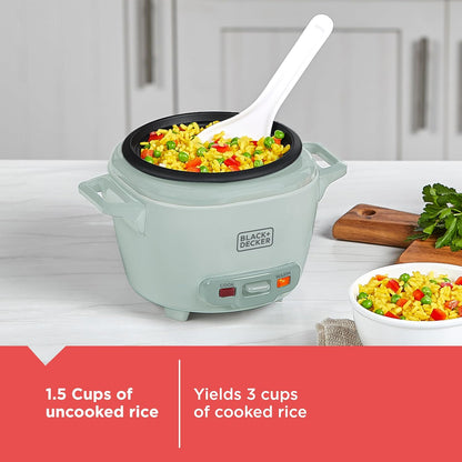 Green rice cooker with cooked rice and vegetables on a kitchen counter, featuring Black+Decker branding.
