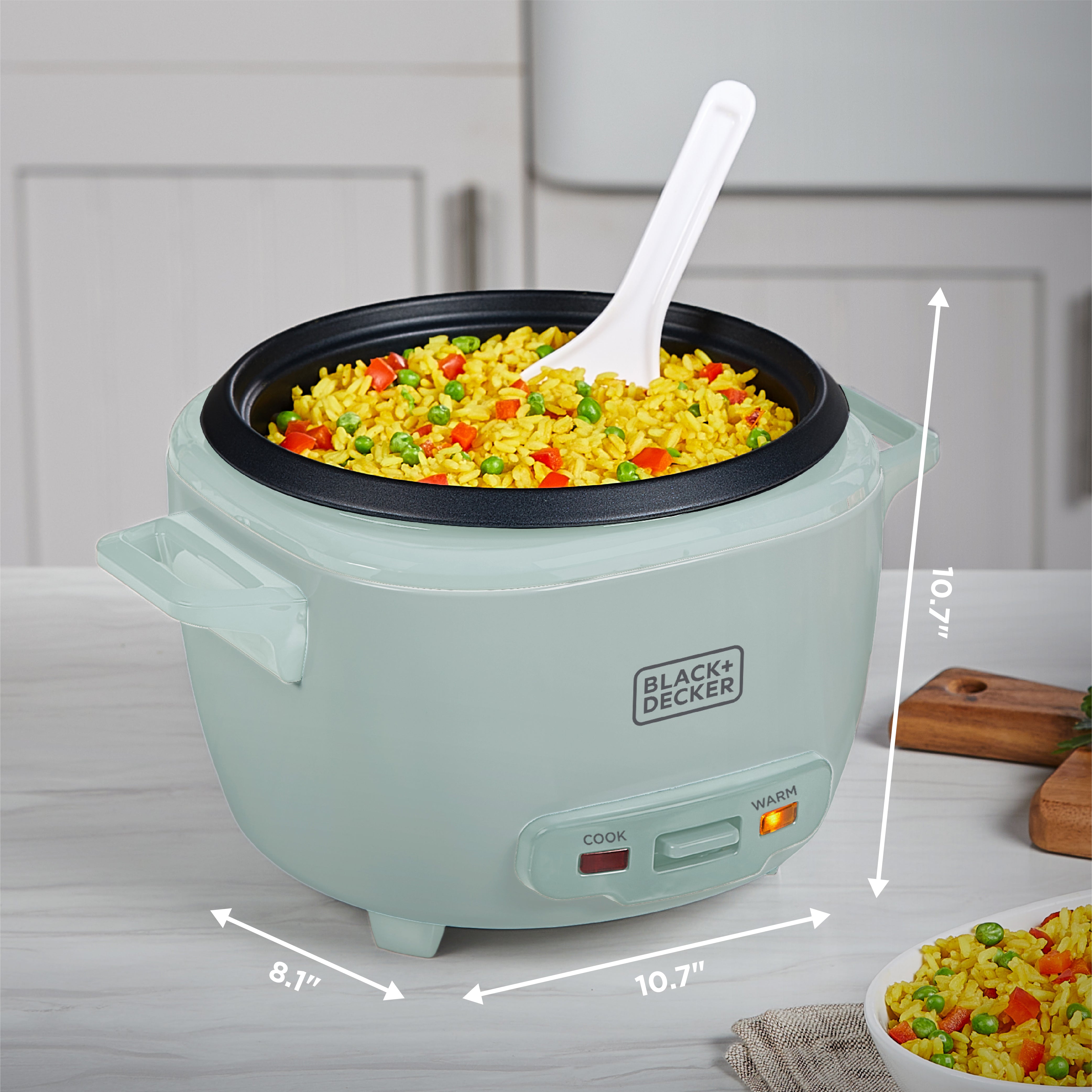 Green rice cooker with cooked vegetables and dimensions displayed