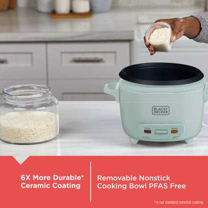 Light green rice cooker on a kitchen counter with a hand adding rice, featuring Black+Decker branding.