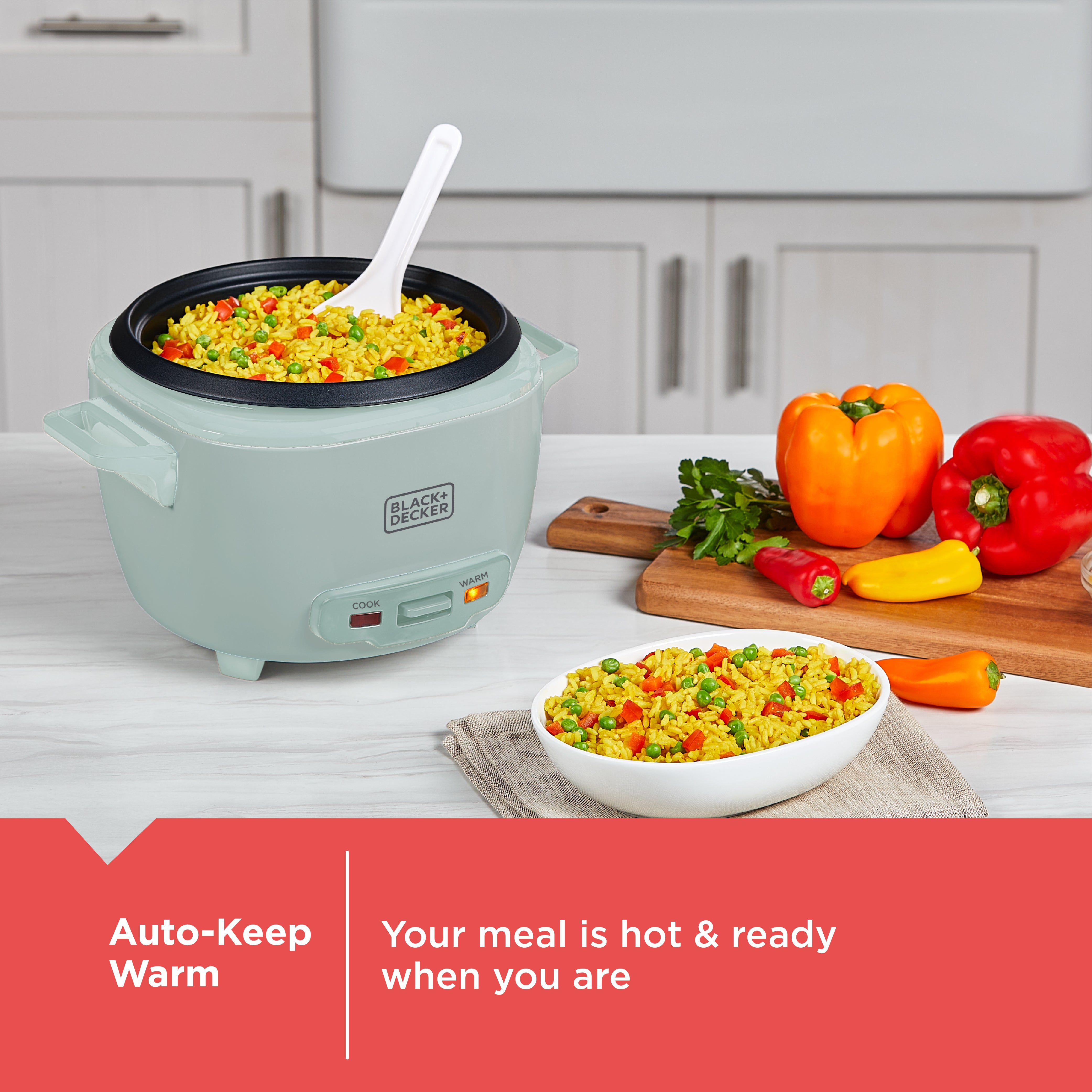 Green rice cooker with cooked rice and vegetables on a kitchen counter, featuring Black+Decker branding.