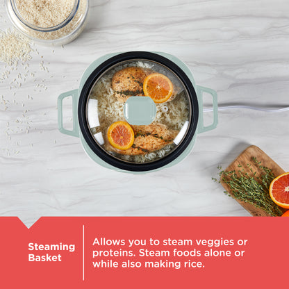 Cooking pot with steaming basket containing food on a light gray surface.
