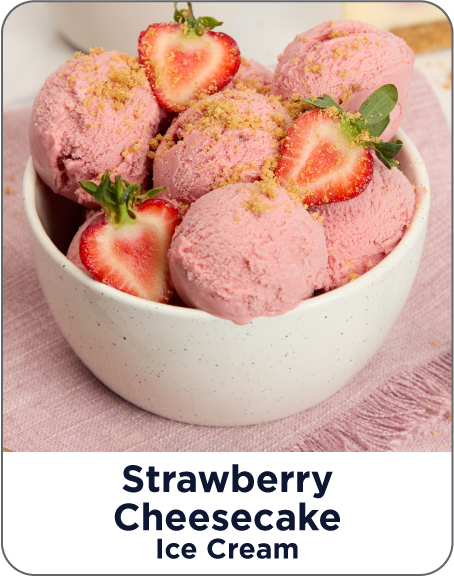 Bowl of strawberry cheesecake ice cream with strawberries on a pink surface