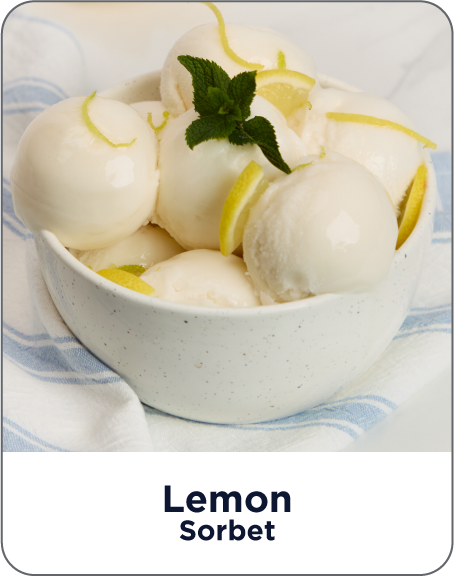 Bowl of lemon sorbet with lemon zest and a mint leaf on a white background