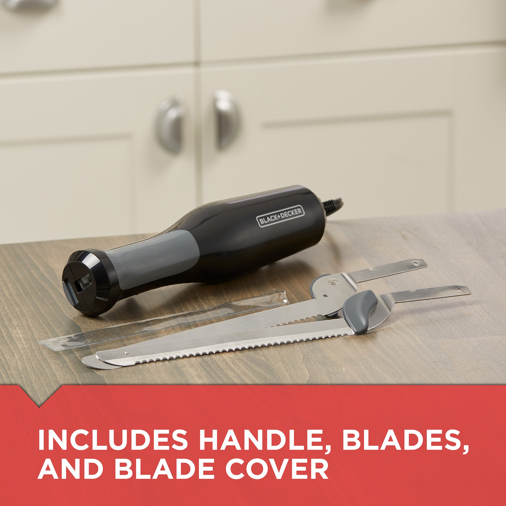 Black and Decker electric knife with blades and blade cover on a wooden surface.