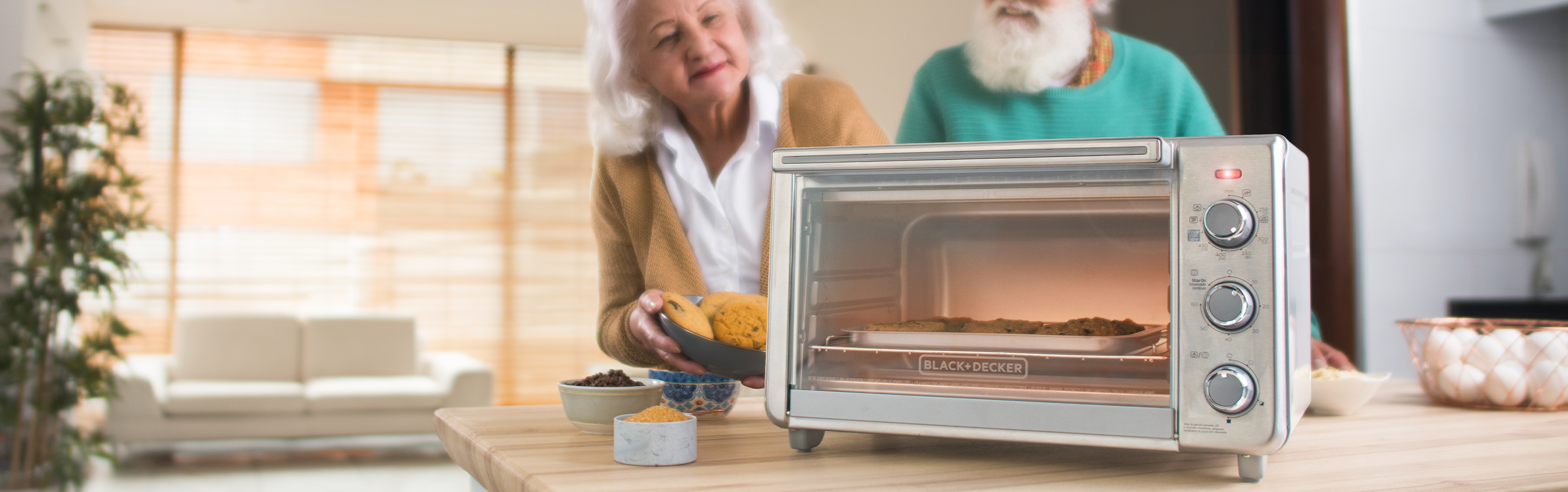 Two people in a kitchen with an oven on a counter