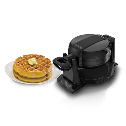 Black waffle maker with two waffles on a white plate on a white background