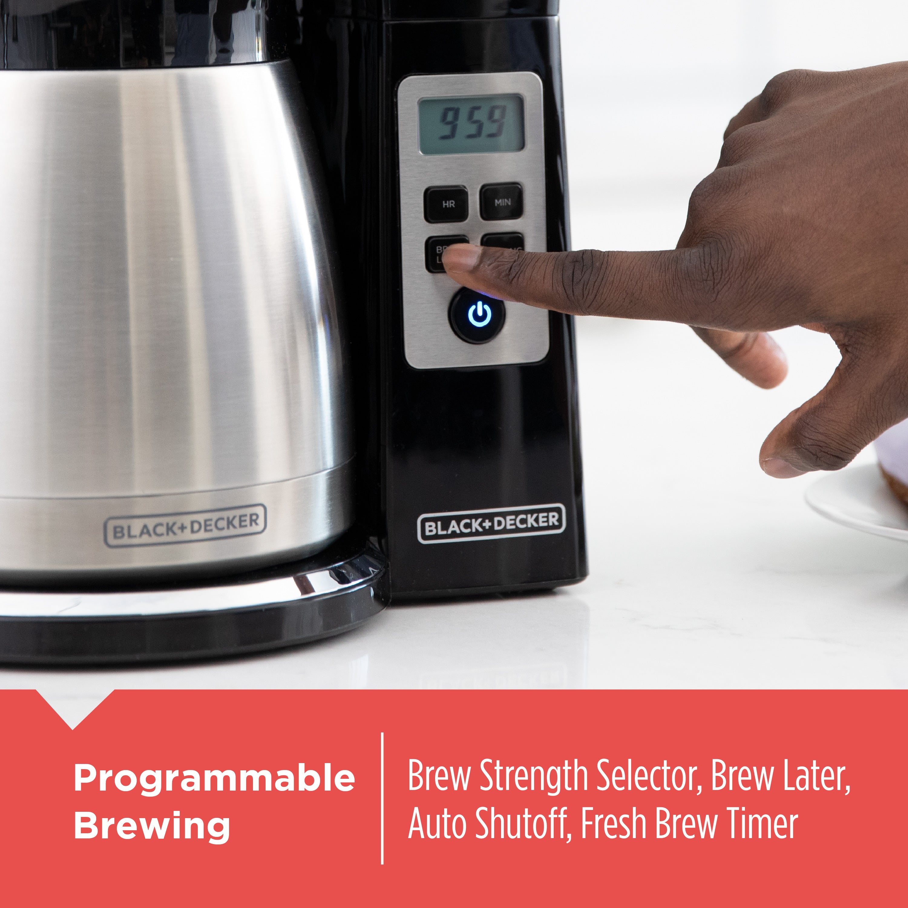 Black and Decker coffee maker with a hand pressing a button, on a white background.