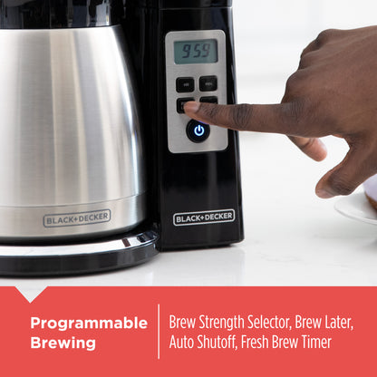 Black and Decker coffee maker with a hand pressing a button, on a white background.