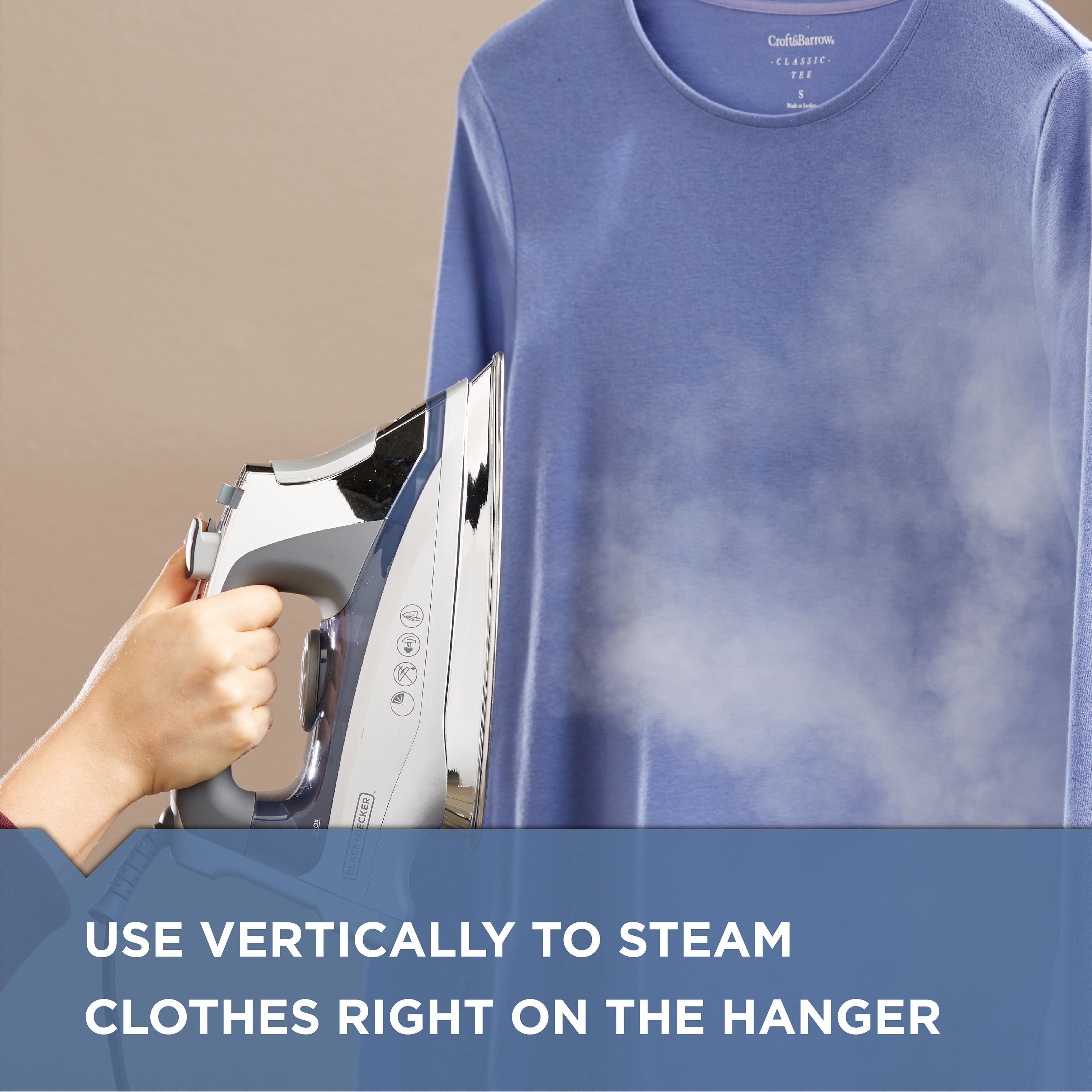 Person using a steam iron on a blue shirt with text 'Use vertically to steam clothes right on the hanger'.