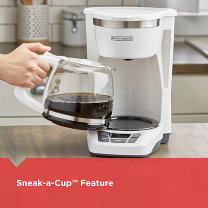 White coffee maker with a person pouring coffee into a glass cup, set against a kitchen background.