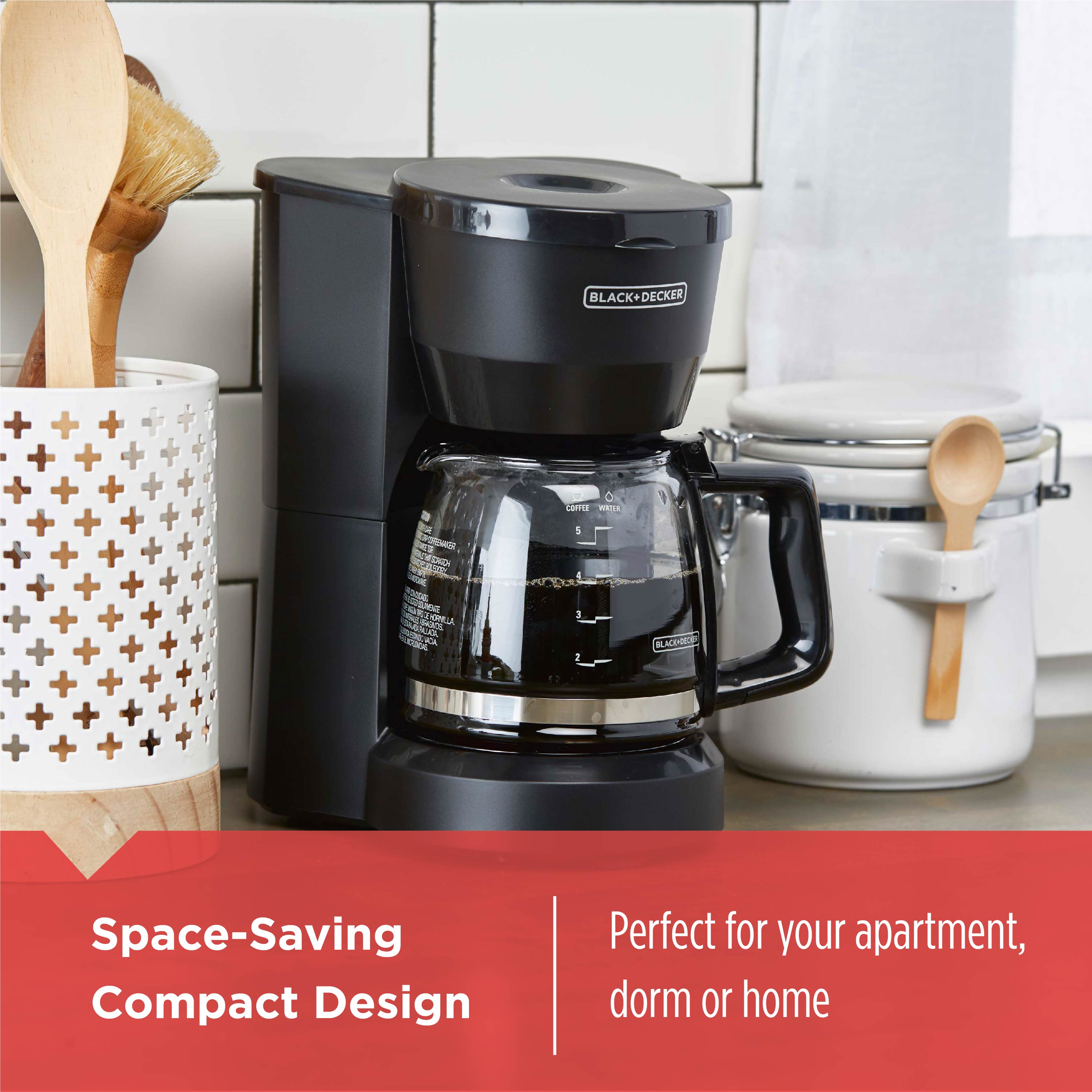 Black coffee maker on a kitchen counter with text about space-saving design