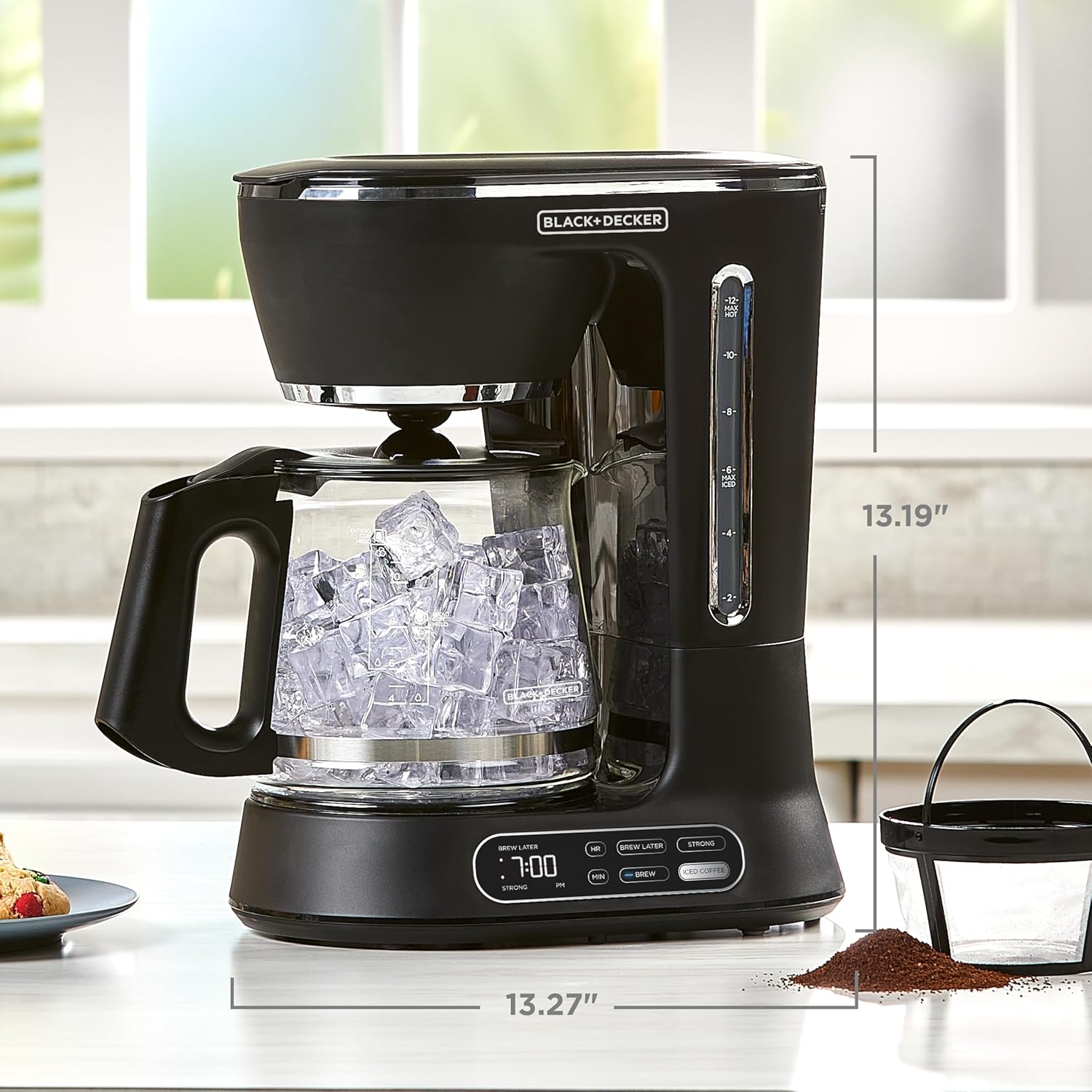 Black coffee maker with glass carafe on a kitchen counter, showing dimensions.