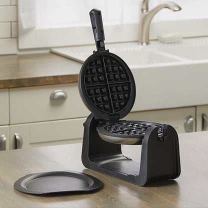 Black waffle maker on a kitchen counter with a sink in the background