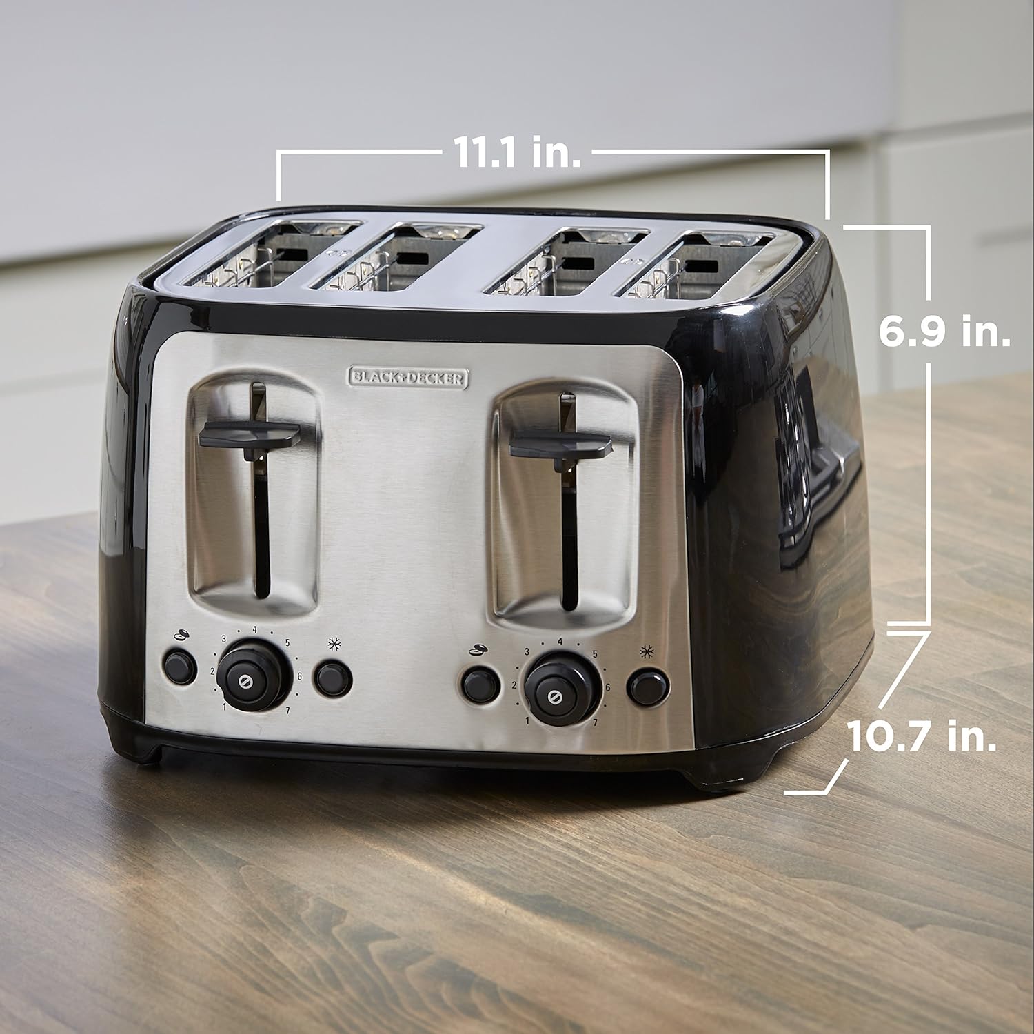 Black and silver toaster with dimensions labeled on a wooden surface
