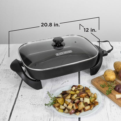 Black and Decker electric skillet with dimensions labeled on a white surface with food.