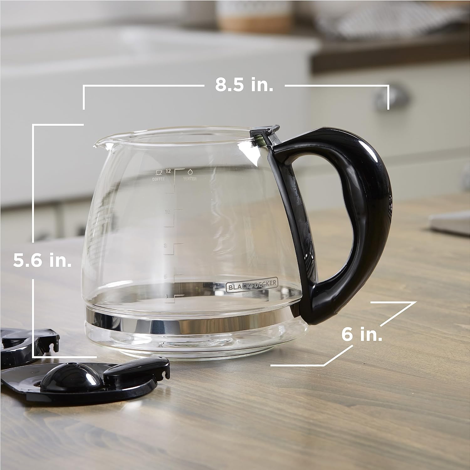 Glass coffee maker with black handle on a wooden surface, showing dimensions.